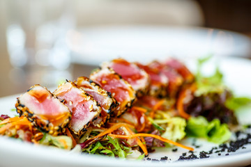 Salad with grilled tuna and lettuce is in the plate.