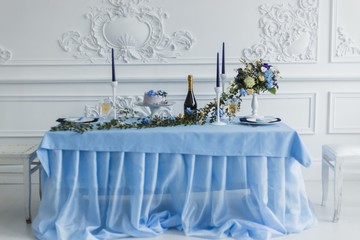 Wedding decorations with candles, cake and bottle with wine and beautiful flowers. serenity color