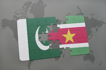 puzzle with the national flag of pakistan and suriname on a world map background.