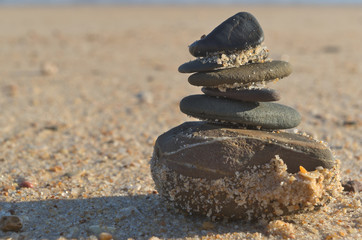 Fototapeta na wymiar Pile of Zen stones at the beach. Nature and wellness Theme