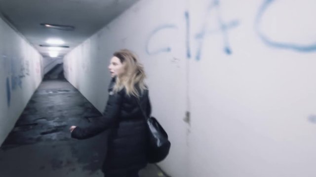 frightened scared woman in panic runs away from murdered rapist bad man shaky effect back view horror dark mood 