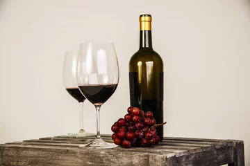 Fotobehang Setup of red wine bottle, full glasses and grapes on a wooden table © clsdesign