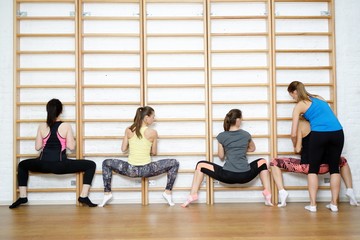 Fitness instructor helps to do exercise on an extension