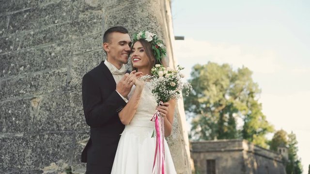Happy groom kissing bride with wreath and tape on head. 4K
