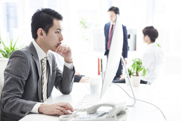 Businessmen are seriously looking at the monitor of the personal computer