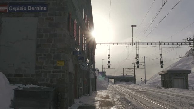 waiting for the  red bernina express train at one of the highest train station railway ospizio bernina in the alps snowy landscape uhd 4k
