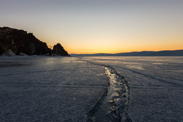 Wide crack in the ice of Lake Baikal to the Shaman Rock