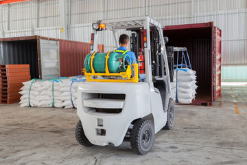 warehouse worker driver by forklift stacker loader material to container box for export at...
