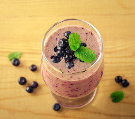 Healthy blueberry banana smoothie with mint and fresh berries in a glass