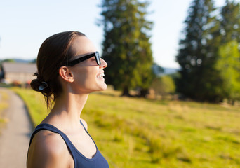 Woman smiling looking up to blue sky taking deep breath celebrating freedom.