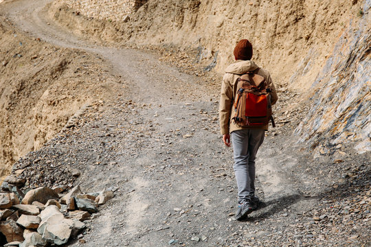 Male Traveler Walking Uphill On Driveway Sand Dune - Upcountry Journey And Travel Concept