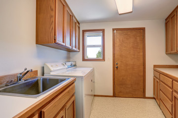 Laundry room with wooden cabinets and stainless sink