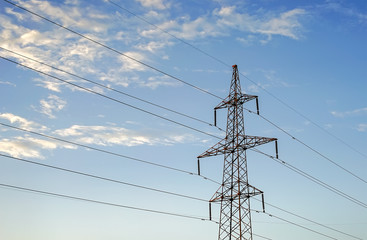 Electricity pylon against the blue sky background.