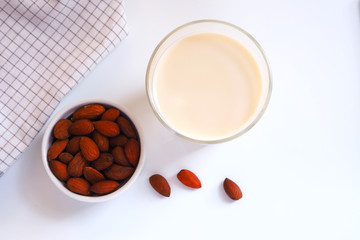 Top view of a healthy glass of almond milk on a white background