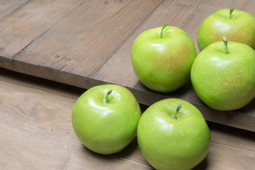 Isolated green apples on wood.