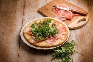 pizza with parmesan ham and arugula