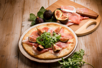 pizza with figs parmesan ham and arugula