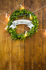 wooden wall and hop wreath with text Just married. Photosession zone