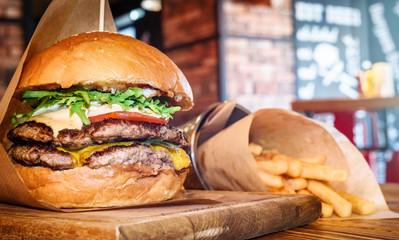 fresh tasty burger and french fries on wooden table