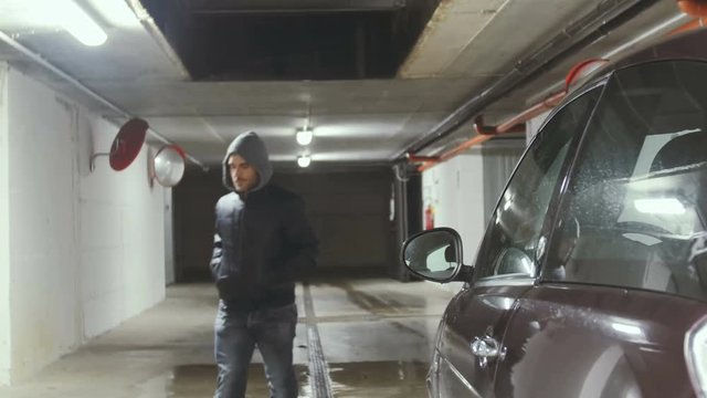 robber man stealing a car underground parking,he forces the door lock