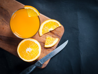 Fresh fruits Orange juice in glass on on a black slate