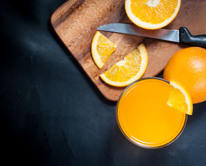 Fresh fruits Orange juice in glass on on a black slate