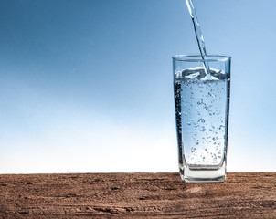 Pouring water on glass on wood