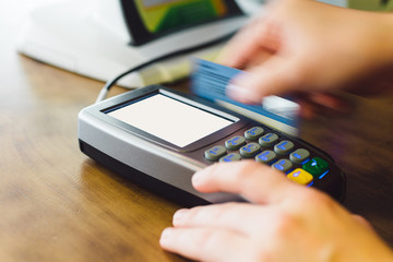 Close up of hand swipe credit card on card-reader machine