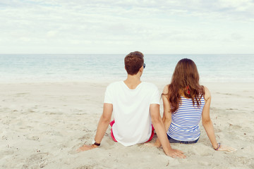 Fototapeta premium Romantic young couple sitting on the beach