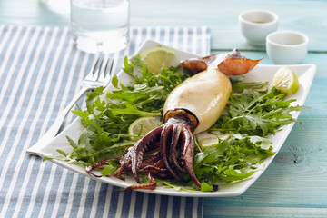 Grilled squid with rocket salad and lemon