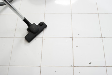 Vacuum cleaning dirt on a tiled floor