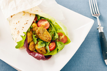 pork wraps on a white serving plate with rocket and lettuce, pastel colors