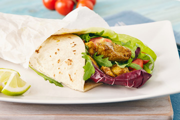 pork wraps on a white serving plate with rocket and lettuce, pastel colors