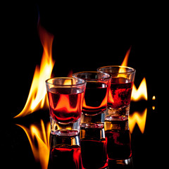 Burning Red cocktail in shot glass on black background