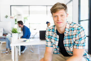 Young man sitting and looking at camera in office