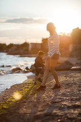 Beautiful woman with a child of four years playing on the beach near the sea