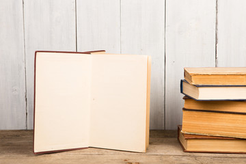 Old and used hardback books or text books on wooden background