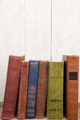 Old and used hardback books or text books on wooden background