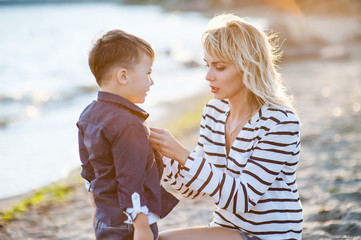 Beautiful woman with a child of four years playing on the beach near the sea