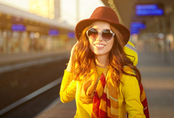 Pretty young woman at a train station (autumn toned image)