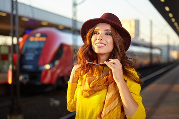 Pretty young woman at a train station (autumn toned image)