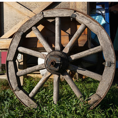 wooden wheel on a background of green grass