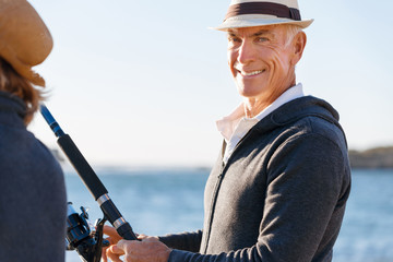 Obraz premium Senior man fishing with his grandson