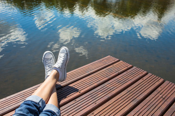 Young girls feet relaxing by a lake. 