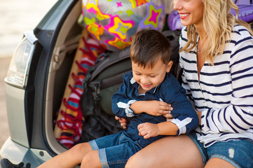 Beautiful woman with a child of four years in the car are going to have a trip