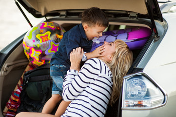 Beautiful woman with a child of four years in the car are going to have a trip