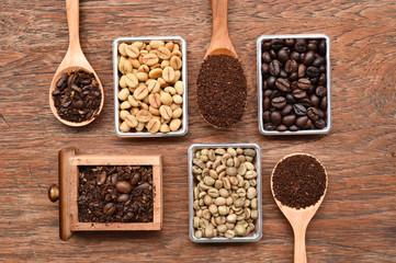 different coffee forms in wooden box and ground coffee in wooden spoon