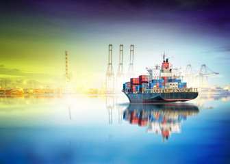 Logistics and transportation of International Container Cargo ship in the ocean with working crane bridge in sea port background