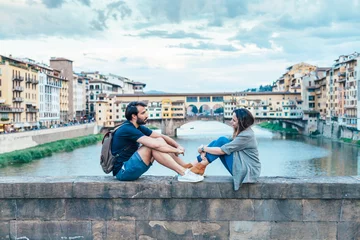 Foto op Plexiglas Ponte Vecchio Paar bij zonsondergang voor de Ponte Vecchio Florence
