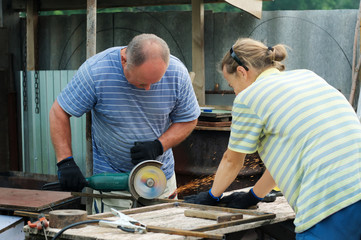 Workers cutting metal with angle grinder